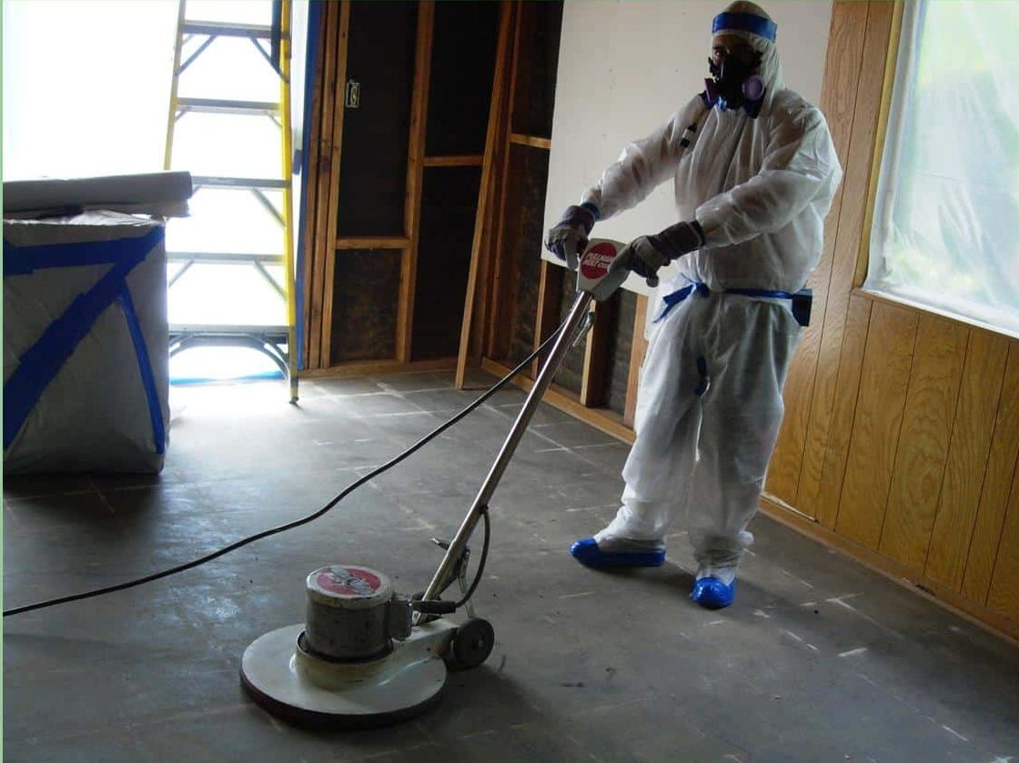 Worker in Hazmat Suit operating a Flooring Machine