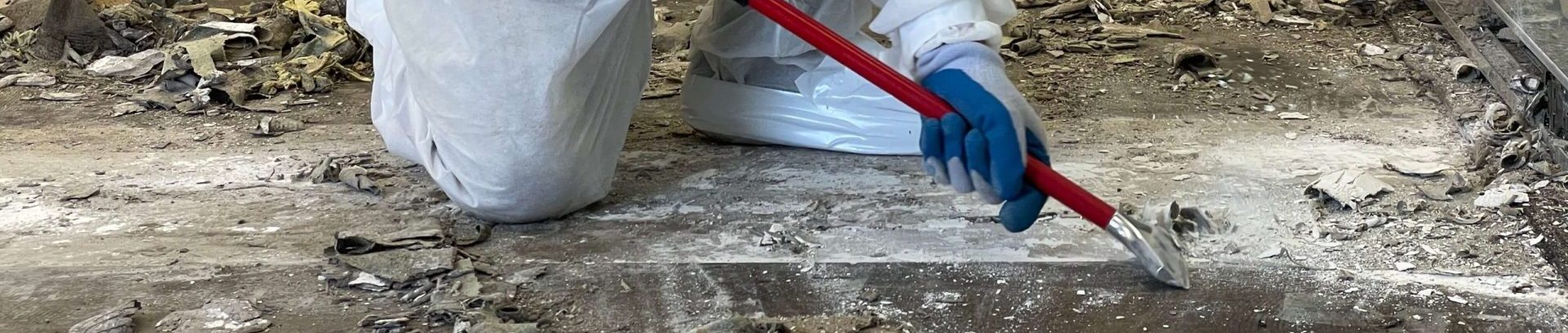 Workers wearing protective gear while they strip the flooring